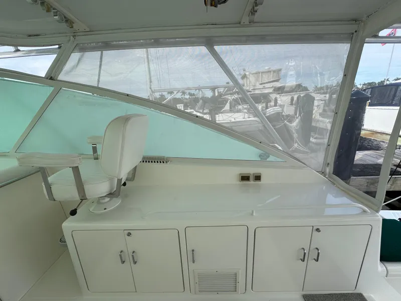 Slide: The Image of 1999 Cabo 45 Express boat interior with white seating and storage cabinets. - 15
