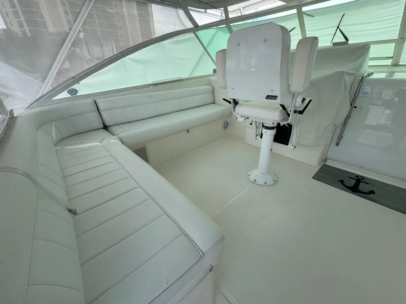 Slide: The Image of 1999 Cabo 45 Express boat interior with white seating and helm chair. - 16