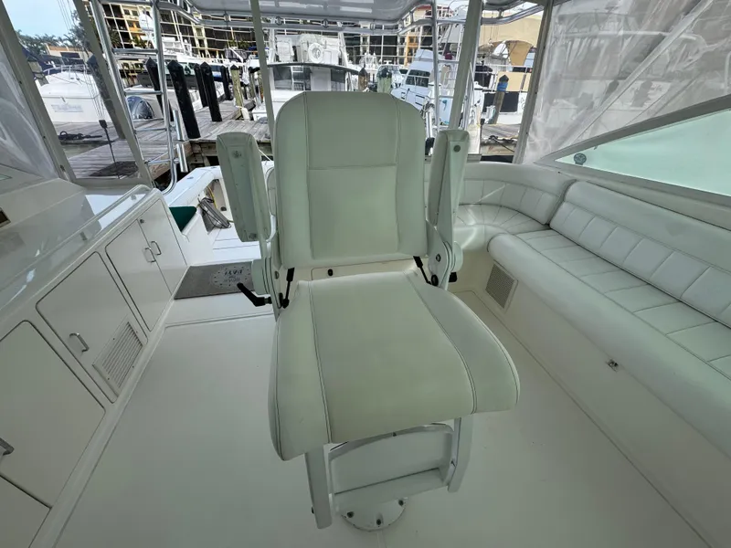 Slide: The Image of Cabo 45 Express 1999 boat interior with white captain's chair and seating area. - 20