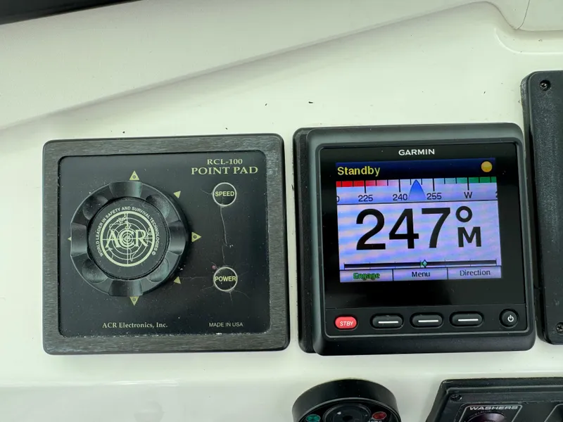 Slide: The Image of Cabo 45 Express 1999 boat navigation controls with Garmin display and ACR point pad. - 24