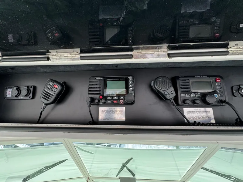 Slide: The Image of Cabo 45 Express 1999 boat dashboard with communication radios and controls. - 25