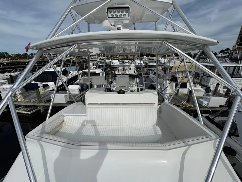 Slide: The Image of 1999 Cabo 45 Express yacht at marina, featuring spacious deck and modern design. - 33