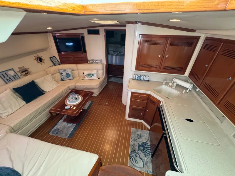 Slide: The Image of Interior of 1999 Cabo 45 Express yacht with cozy seating and wooden cabinetry. - 36