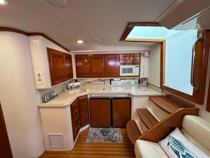 Slide: The Image of Luxurious 1999 Cabo 45 Express yacht interior with modern kitchen and wooden cabinetry. - 37