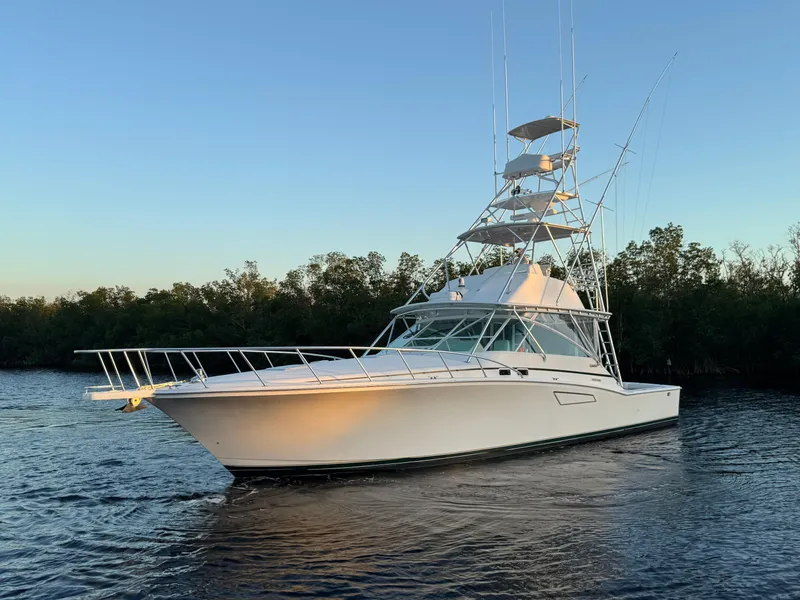 Slide: The Image of 1999 Cabo 45 Express yacht on calm water at sunset. - 4