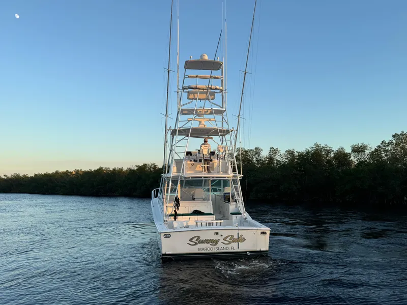 Slide: The Image of 1999 Cabo 45 Express boat cruising on a calm river at sunset. - 9