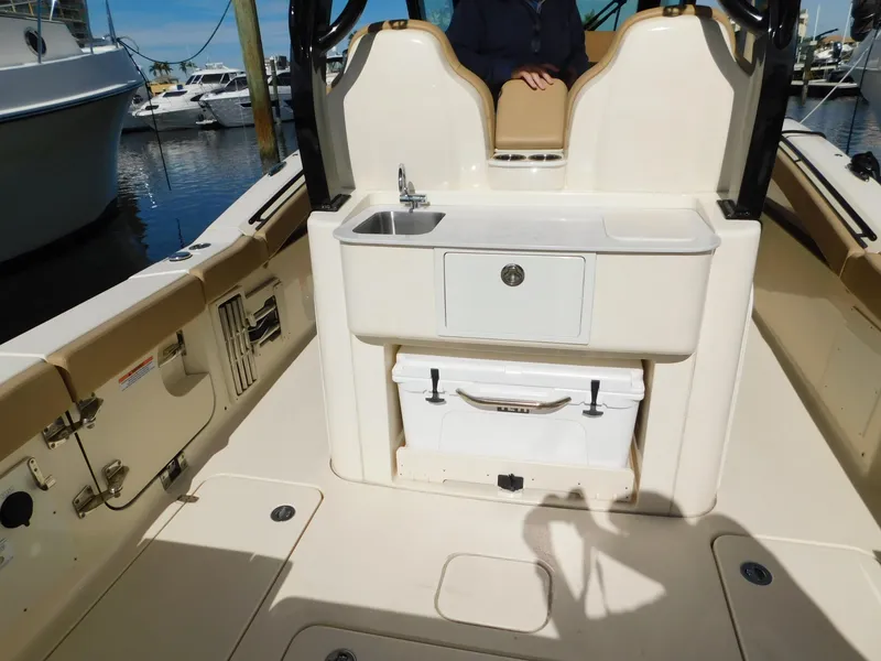 Slide: The Image of 2024 Scout 33LXF boat interior with sink and storage, docked at marina. - 14