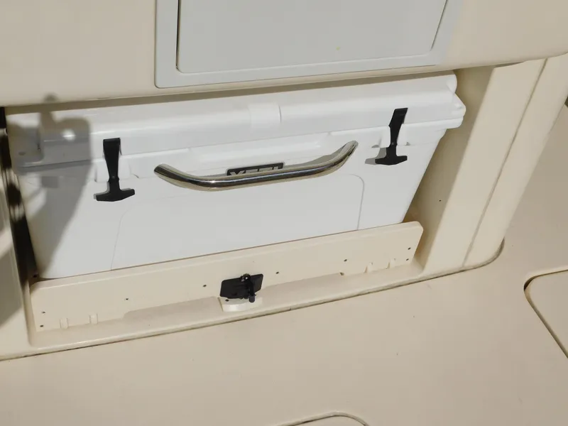 Slide: The Image of 2024 Scout 33LXF boat cooler storage compartment with secure latch. - 15