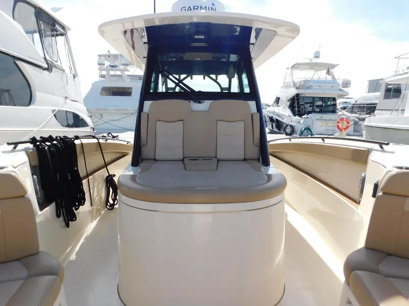 Slide: The Image of 2024 Scout 33LXF boat interior with seating and navigation equipment at a marina. - 28