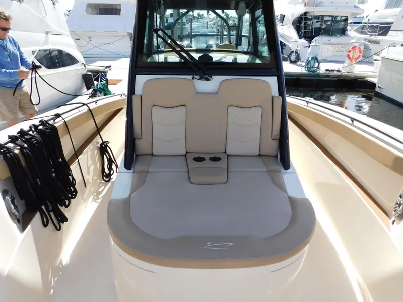 Slide: The Image of 2024 Scout 33LXF boat interior with cushioned seating at a marina. - 29