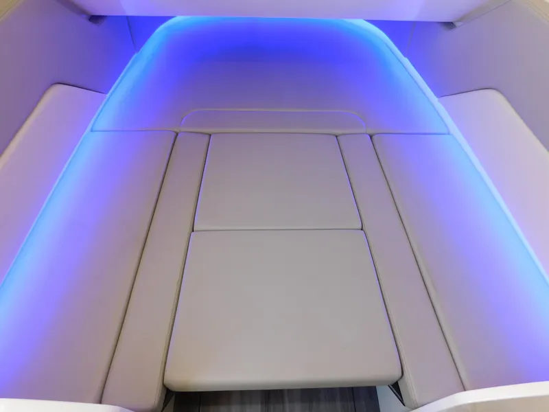 Slide: The Image of 2024 Scout 33LXF boat interior with blue LED lighting and cushioned seating. - 31