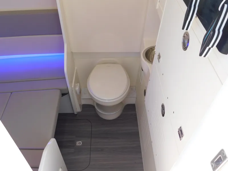 Slide: The Image of 2024 Scout 33LXF boat interior bathroom with modern toilet and seating area. - 32