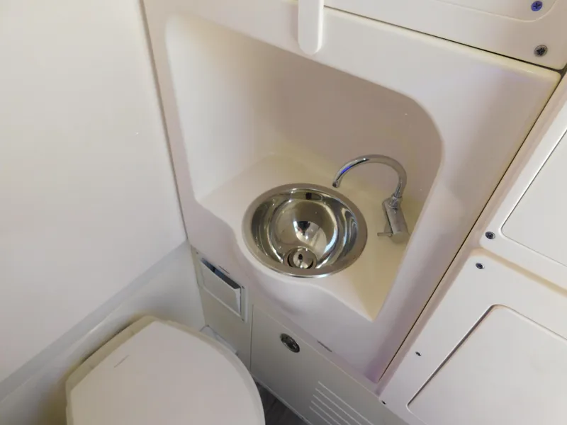 Slide: The Image of 2024 Scout 33LXF boat bathroom with compact sink and toilet. - 35