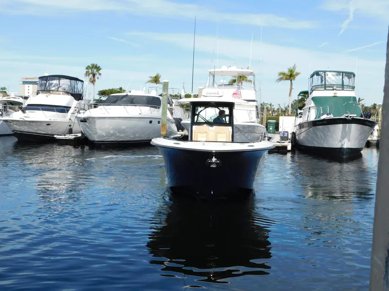 Slide: The Image of 2024 Scout 33LXF boat docked among other yachts in a marina. - 4