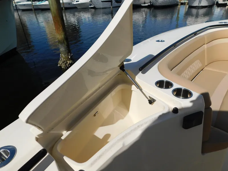 Slide: The Image of 2024 Scout 33LXF boat with open storage compartment and cup holders. - 41