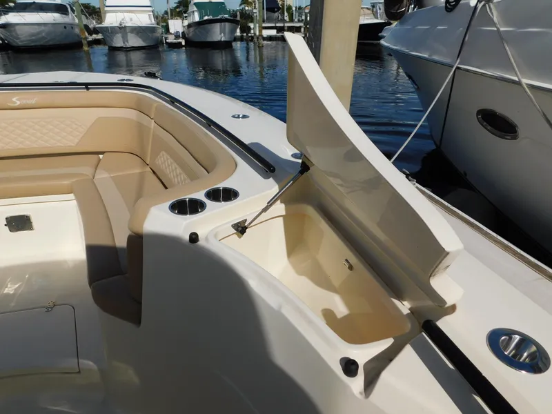 Slide: The Image of 2024 Scout 33LXF boat interior with open storage compartment and cup holders. - 42