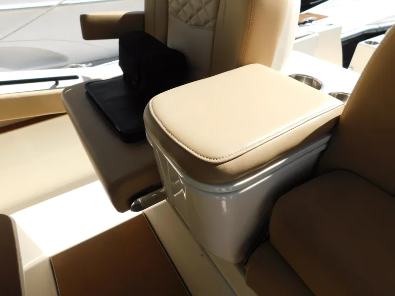 Slide: The Image of 2024 Scout 33LXF boat interior with beige seating and armrest. - 49