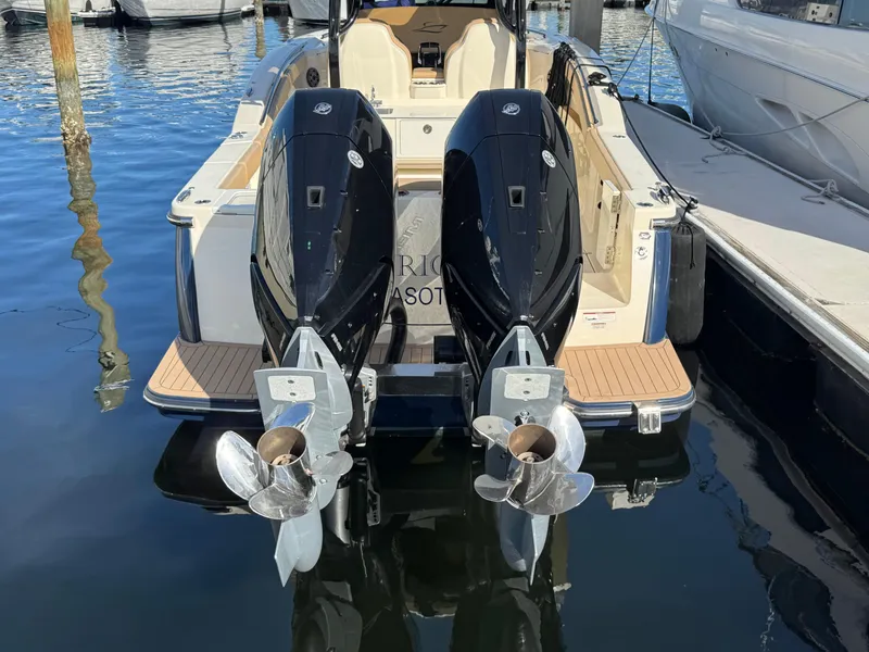 Slide: The Image of 2024 Scout 33LXF boat with dual outboard engines docked at marina. - 6