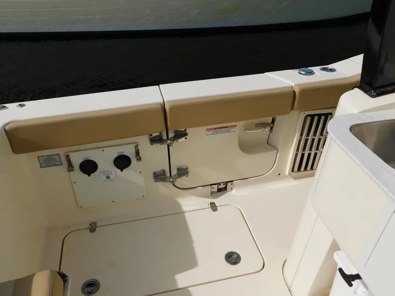 Slide: The Image of 2024 Scout 33LXF boat interior with beige seating and utility access. - 8