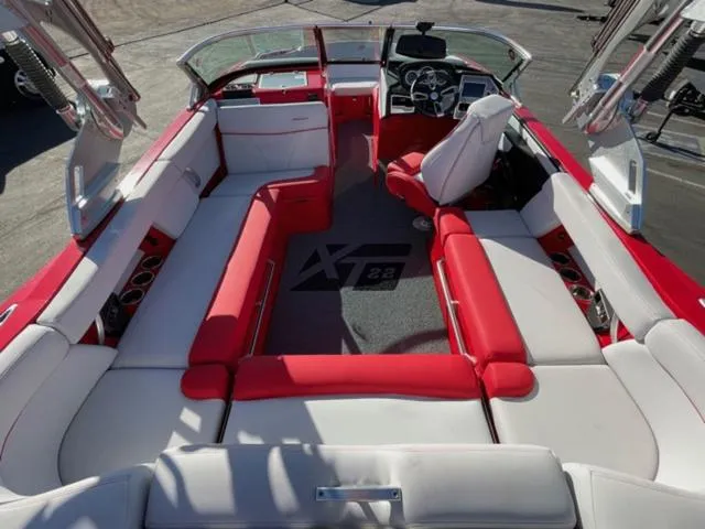 Slide: The Image of 2020 MasterCraft XT22 boat interior with red and white seating, modern dashboard, and spacious layout. - 10