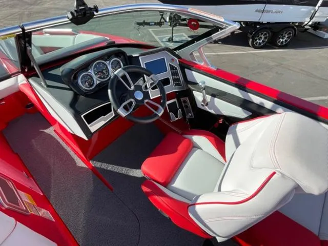 Slide: The Image of 2020 MasterCraft XT22 boat interior with red and white seating, modern dashboard, and steering wheel. - 11