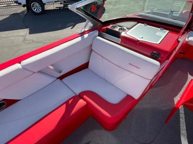 Slide: The Image of 2020 MasterCraft XT22 boat interior with red and white seating, cup holders, and dashboard. - 12