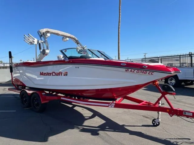Slide: The Image of 2020 MasterCraft XT22 boat on trailer, red and white design, parked outdoors. - 4