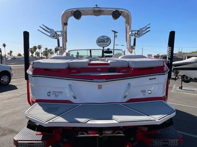 Slide: The Image of 2020 MasterCraft XT22 boat, rear view, red and white design, parked outdoors. - 7
