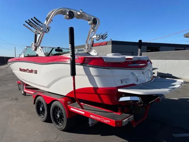 Slide: The Image of 2020 MasterCraft XT22 boat with red and white design on a trailer. - 8