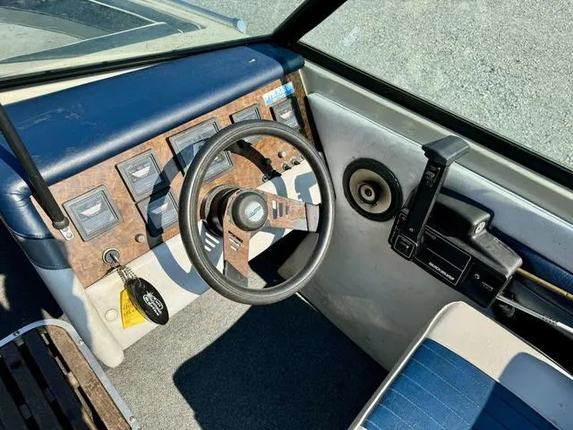 Slide: The Image of 1989 Glassport 175 BR boat dashboard with steering wheel and control panel. - 12