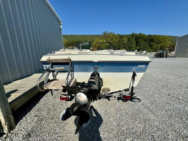 Slide: The Image of 1989 Glassport 175 BR boat on gravel near metal building, clear sky background. - 5