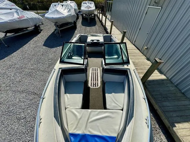 Slide: The Image of 1989 Glassport 175 BR boat with open bow seating, parked near covered boats. - 7
