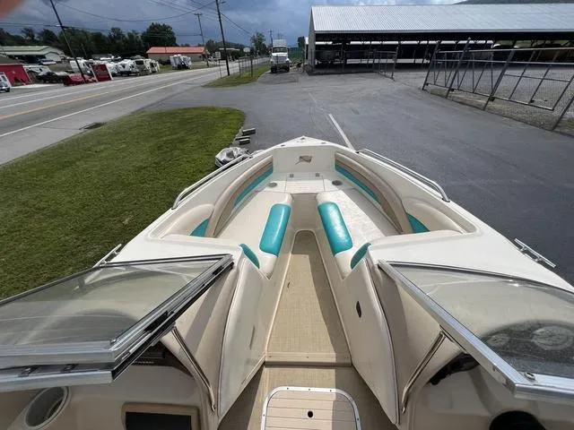 Slide: The Image of 2002 Stingray 200LS/LX boat with open bow seating, parked near a road and storage facility. - 14