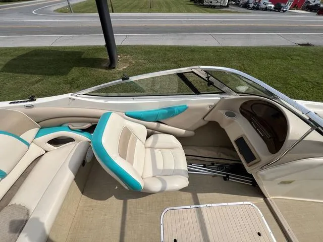 Slide: The Image of 2002 Stingray 200LS/LX boat interior with beige and teal seating, near a road. - 15