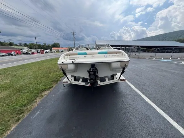 Slide: The Image of 2002 Stingray 200LS/LX boat on trailer, parked on asphalt near grassy area. - 3