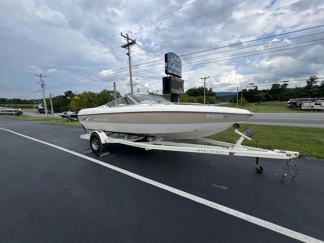 Slide: The Image of 2002 Stingray 200LS/LX boat on trailer, parked on roadside under cloudy sky. - 5