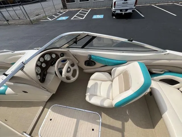 Slide: The Image of 2002 Stingray 200LS/LX boat interior with beige and teal seating, steering wheel, and dashboard. - 6