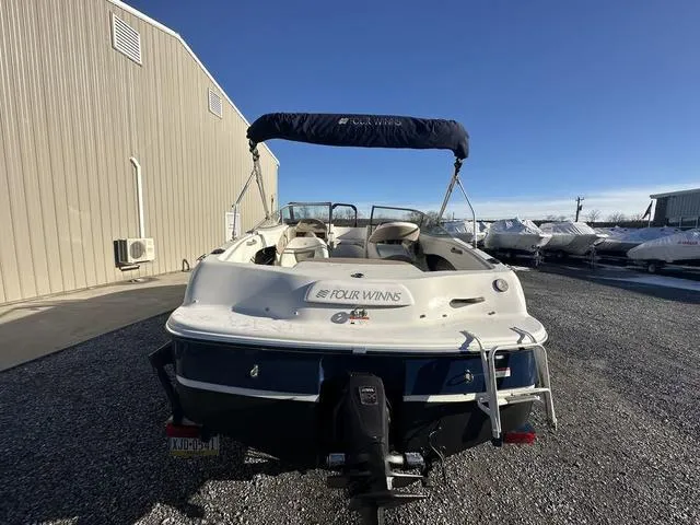 Slide: The Image of 2005 Four Winns 190 Horizon boat, rear view, parked on gravel near storage facility. - 15