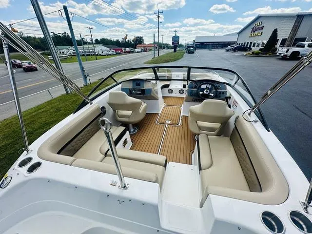 Slide: The Image of 2022 Hurricane SunDeck 191 OB boat interior with seating and steering wheel, parked outdoors. - 8