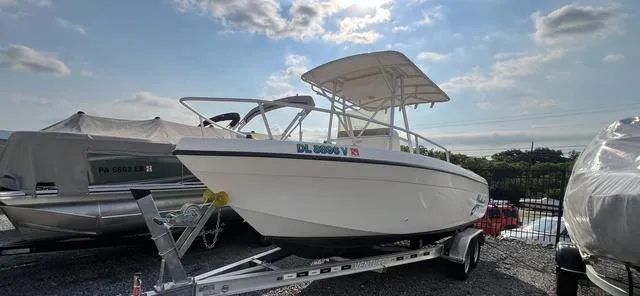 Slide: The Image of 2001 Carolina Skiff 2100 boat on trailer under a partly cloudy sky. - 5
