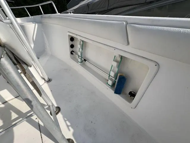 Slide: The Image of 2001 Carolina Skiff 2100 boat interior with storage compartment and cleaning supplies. - 9