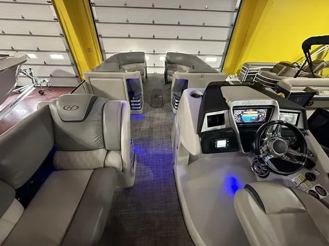 Slide: The Image of Interior of 2018 Harris Grand Mariner SEL 250 pontoon boat with luxurious seating and modern dashboard. - 2