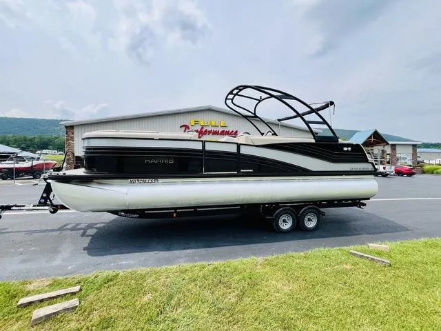 Slide: The Image of 2018 Harris Grand Mariner SEL 250 pontoon boat on trailer, parked outside dealership. - 3