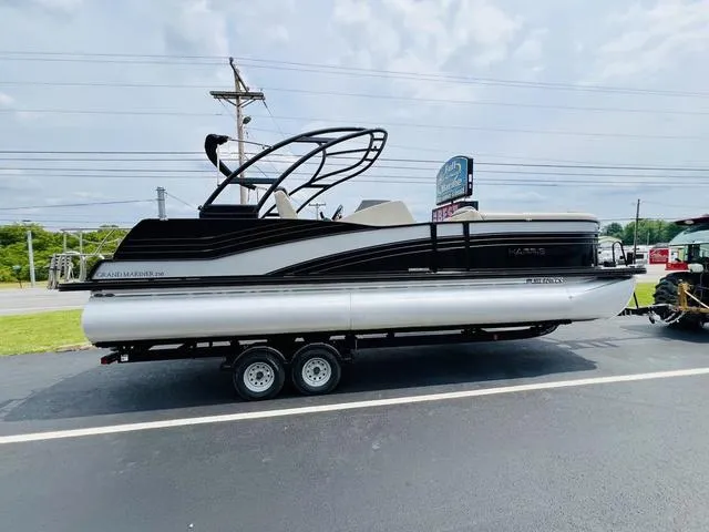 Slide: The Image of 2018 Harris Grand Mariner SEL 250 pontoon boat on trailer, parked outdoors. - 4