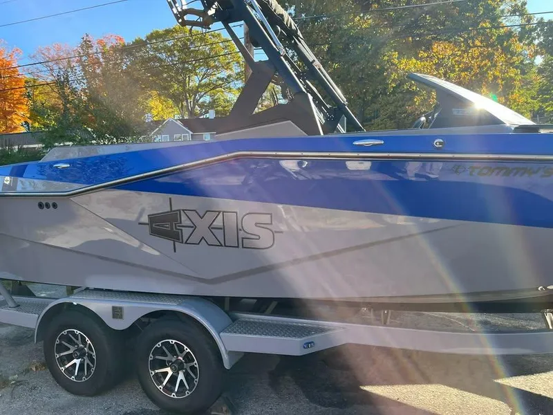 Slide: The Image of 2023 Axis T220 boat on trailer, blue and gray design, parked outdoors. - 3