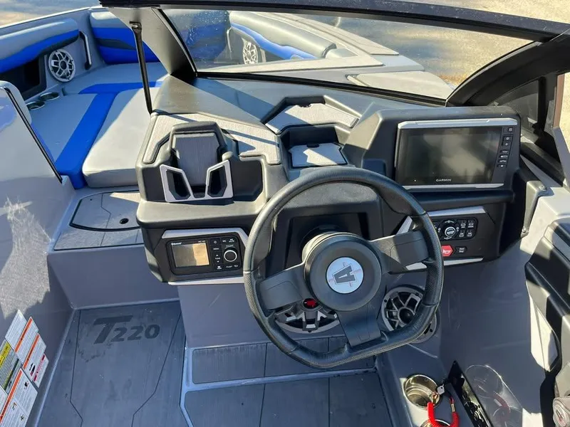 Slide: The Image of 2023 Axis T220 boat dashboard with steering wheel, controls, and navigation screen. - 4