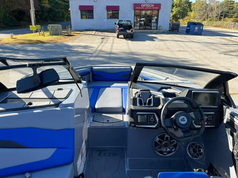 Slide: The Image of 2023 Axis T220 boat interior with blue accents, parked near Optech building. - 5
