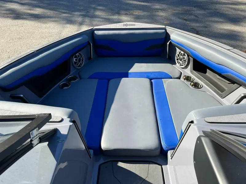 Slide: The Image of 2023 Axis T220 boat interior with blue and gray seating, cup holders, and speakers. - 6