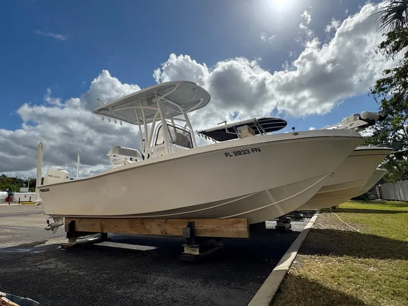 Slide: The Image of 1986 Mako 224 CC boat on display under a cloudy sky. - 0