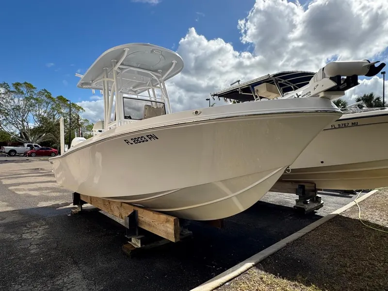 Slide: The Image of 1986 Mako 224 CC boat on display under cloudy sky. - 1